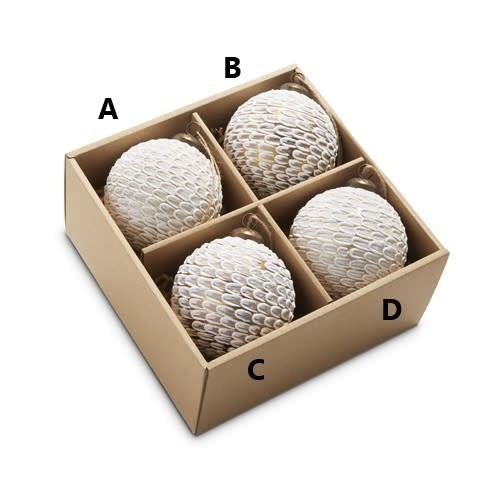 Four white glass ball ornaments with feather-like textured patterns in a cardboard display box.
