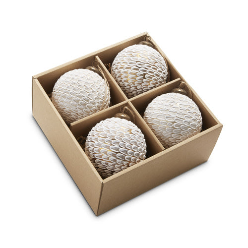 Four white, feather-textured glass ball ornaments in a square cardboard gift box.