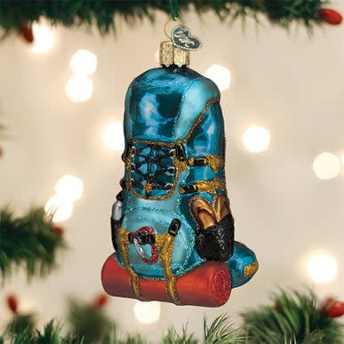 Glass ornament shaped like a hiking backpack with visible straps in natural light.