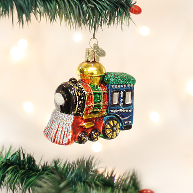 Small red metal locomotive ornament with black wheels and gold accents.