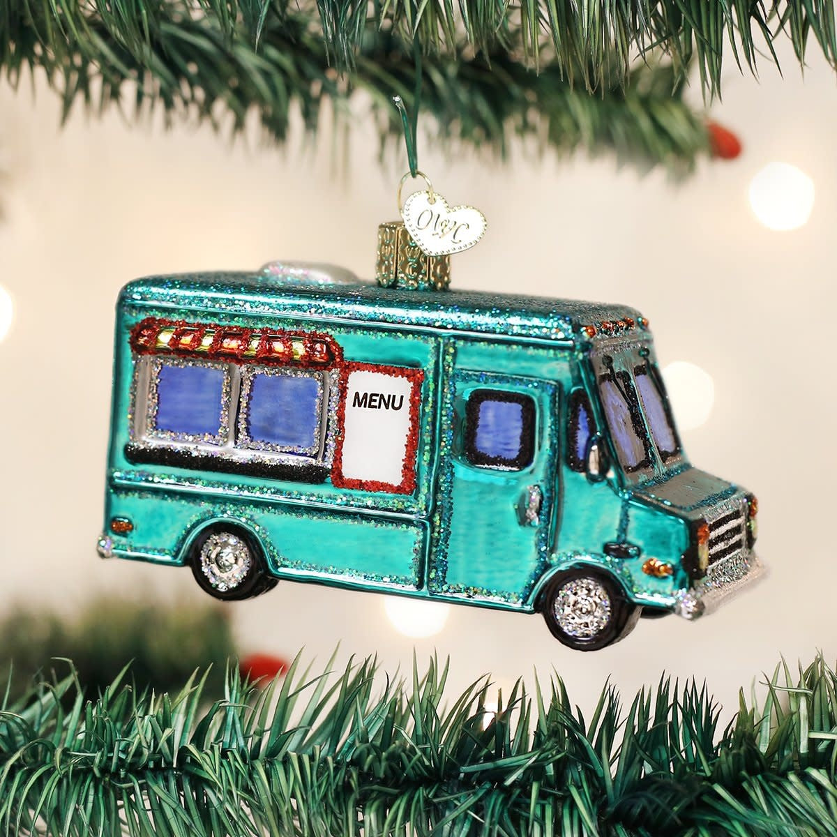 Metal food truck ornament with red cab, yellow trailer, black wheels, and white serving window.