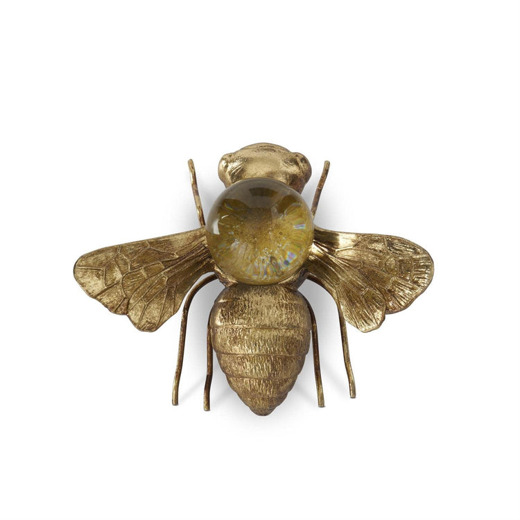 Gold resin bee figurine with a clear glass globe perched on its back.