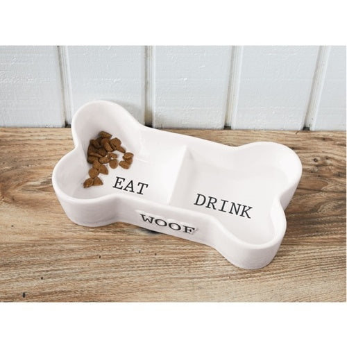 Ceramic dog bowl shaped like a bone with embossed WOOF text and divided EAT DRINK wells.