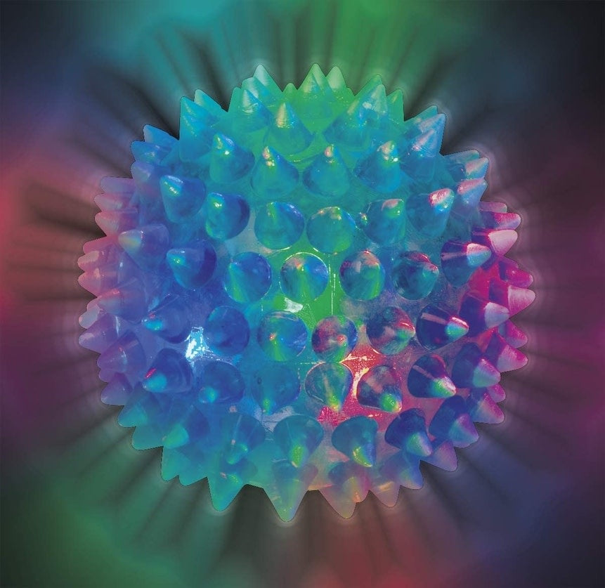 Two spiky bouncy balls with flashing colored lights in a party gift bag.