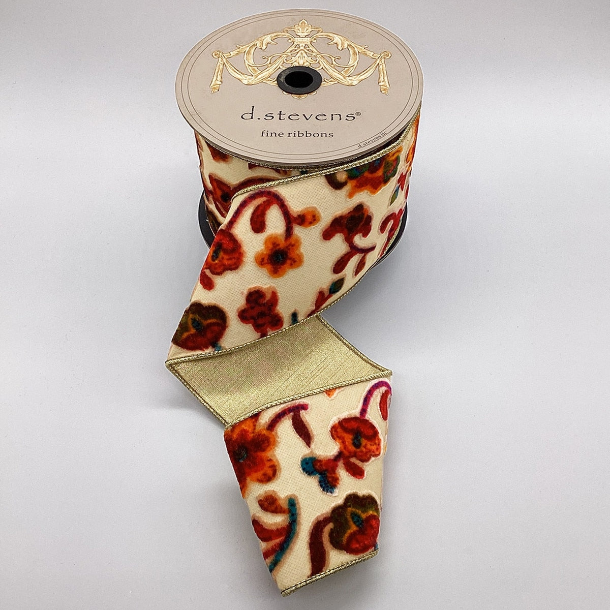 4-inch burnt out velvet eden floral ribbon in cream, hot pink, and orange on a spool.