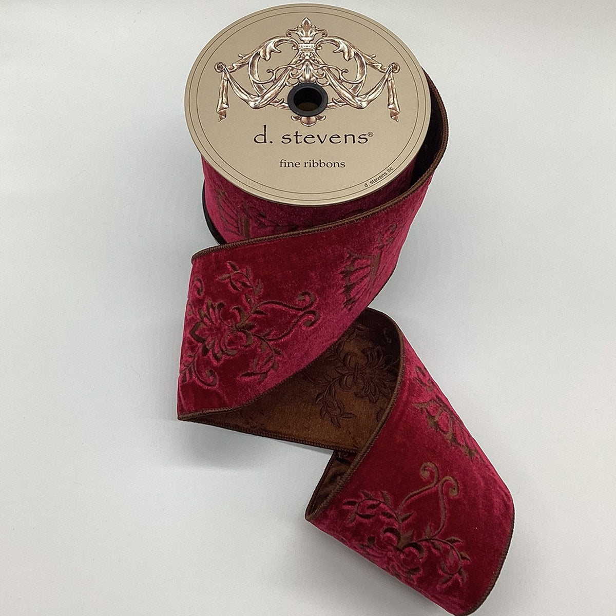 4 inch burgundy velvet ribbon with majestic scroll embroidery on a spool.