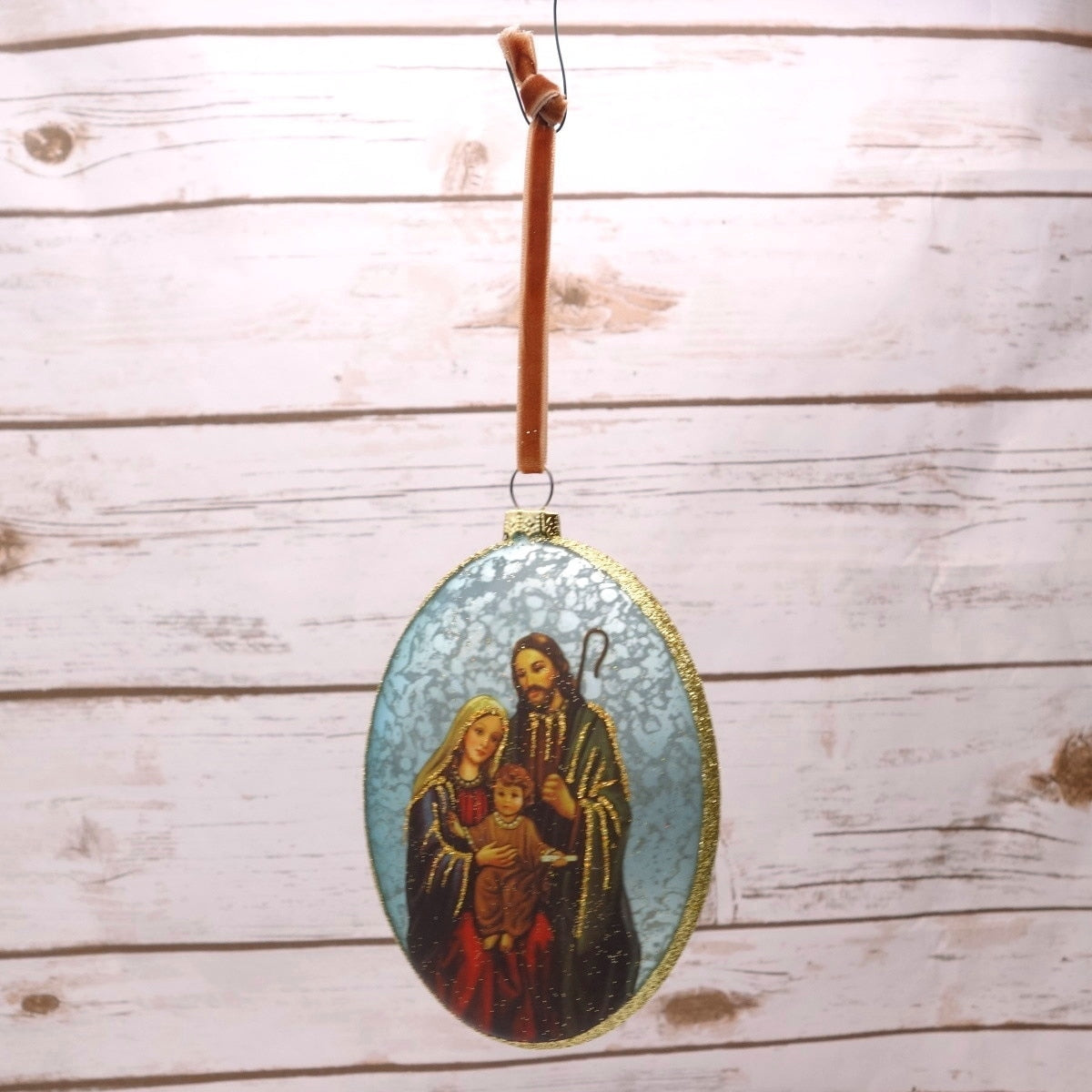 Holy Family oval glass medallion ornament in vintage blue with gold glitter trim and velvet ribbon.