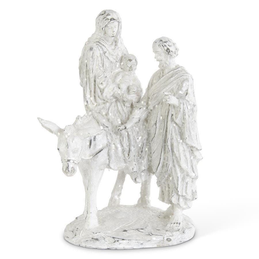 White glittered polyresin figurine of Mary riding a donkey with Joseph and baby Jesus.
