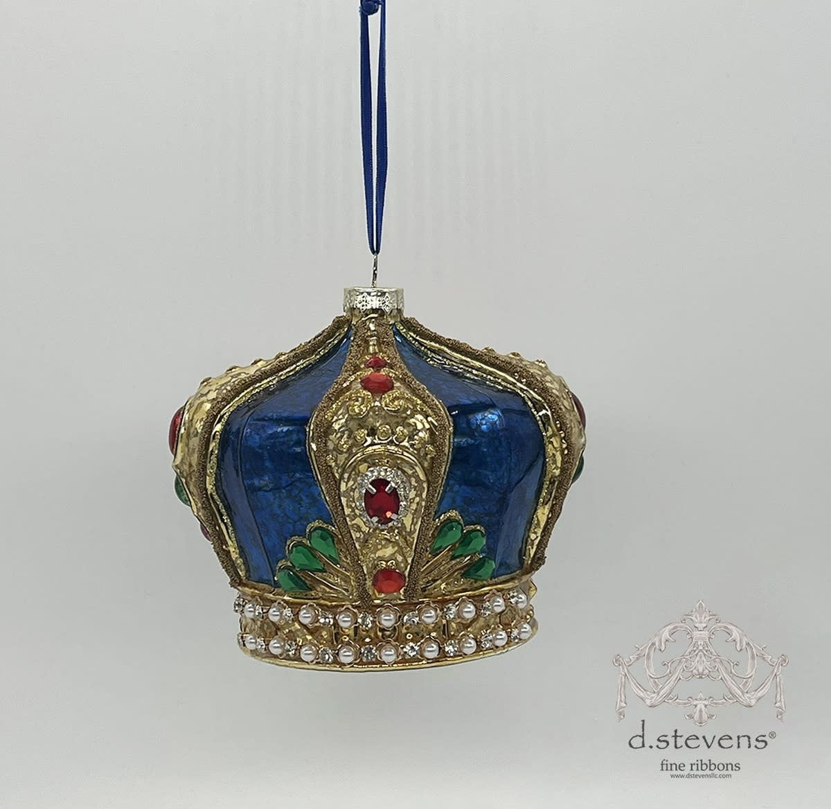 Blue glass jeweled crown ornament with faceted stones on a royal blue base.