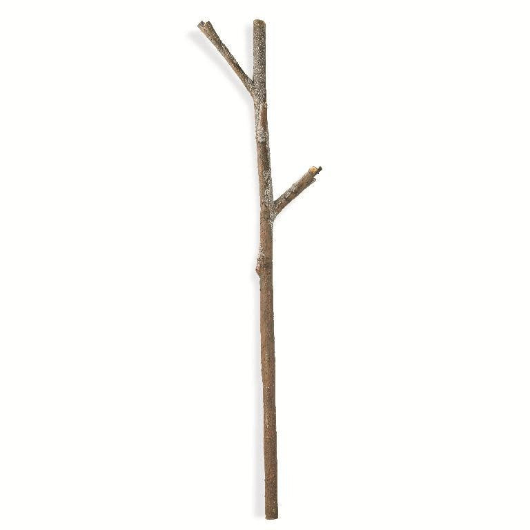 A tall snowy log branch made of frosted styrofoam with a rustic winter silhouette.