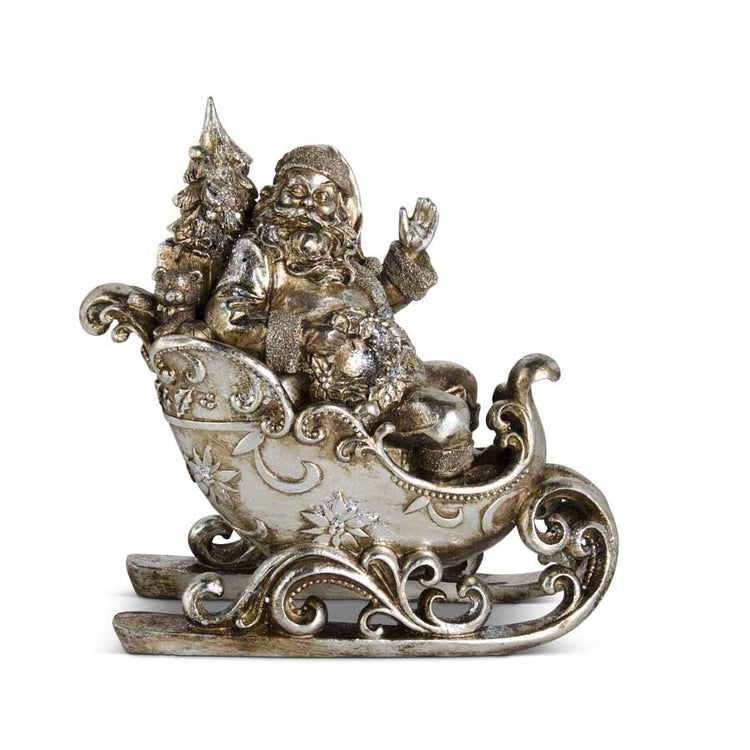 Antique silver resin Santa Claus figurine sitting in a decorative sleigh, 12.75 inches tall.