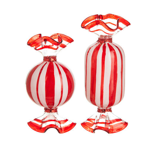 Glass peppermint candy ornament with red swirls on white background