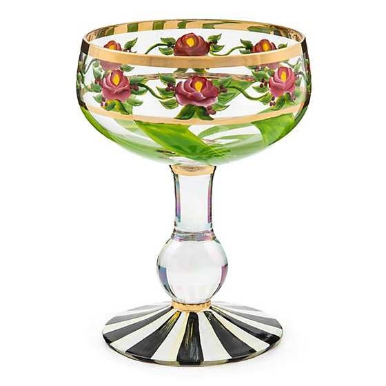Hand-painted Maypole Coupe glass with green ribbon swirls, pink roses, pearlescent stem, and gold lustre on a Courtly Stripe base.