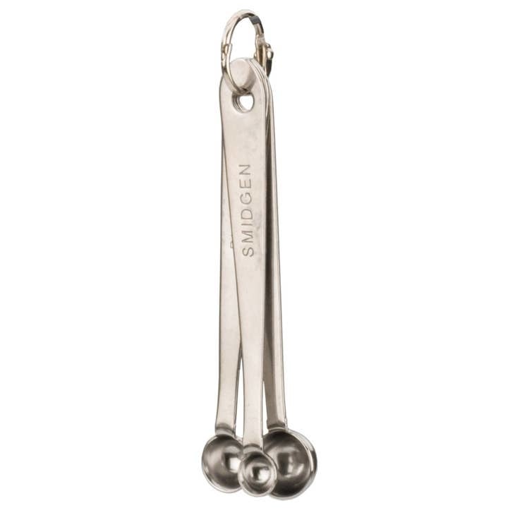 Three stainless steel measuring spoons with rounded bottoms in a set.