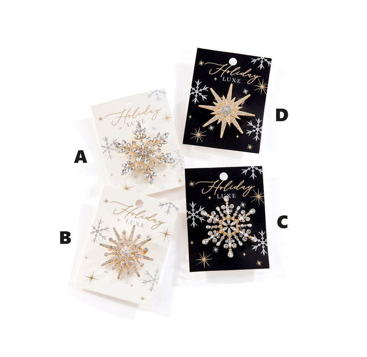 Silver-tone crystal snowflake brooch with glistening facets on a dark background