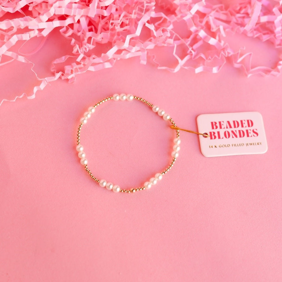 6.75-inch gold pearl bracelet on elastic string with small round pearls.