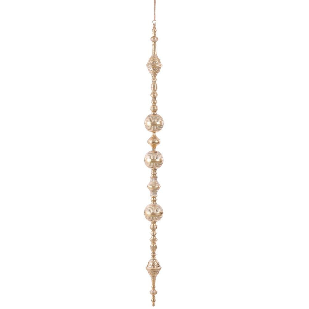 Gold metal finial ornament with rope accents hanging from a tree branch