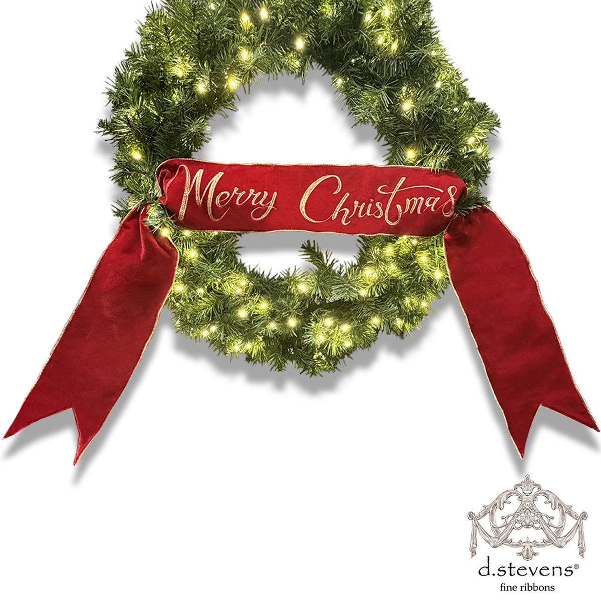 Red velvet banner with gold embroidered Merry Christmas text draped across a lit evergreen wreath.