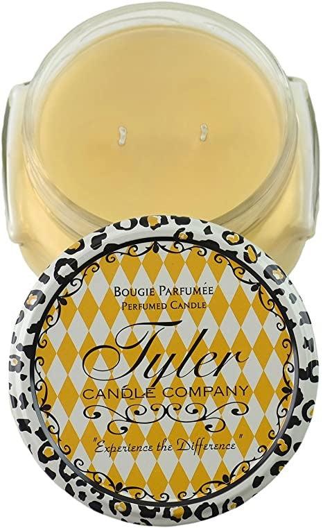 A white ceramic jar containing a Tyler Candle with visible wax and wicks.