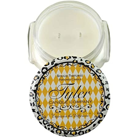 A clear glass jar containing a white candle with the label Tyler Candle.