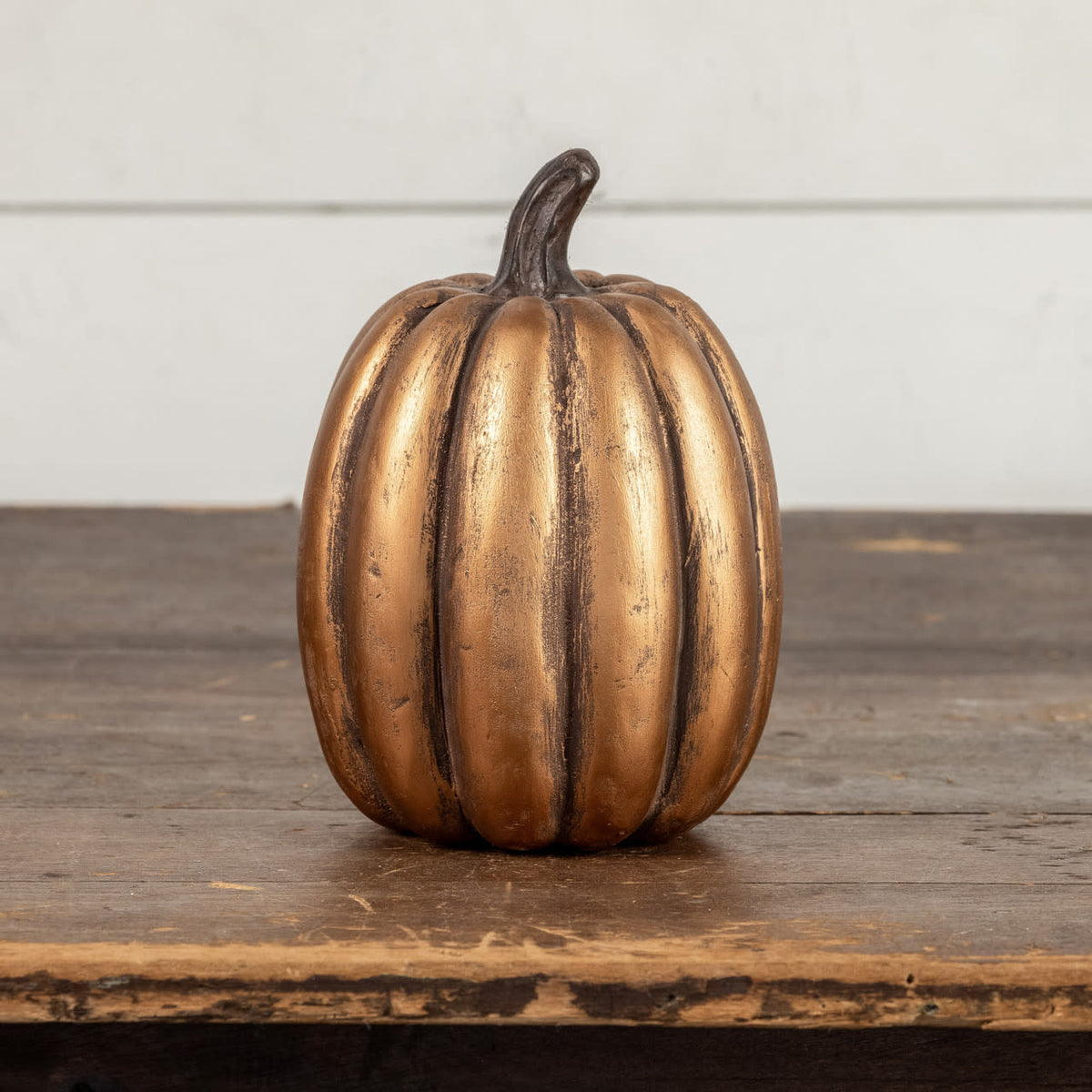 Gold maché tall pumpkin with a sleek finish measuring 7.5 inches in height.