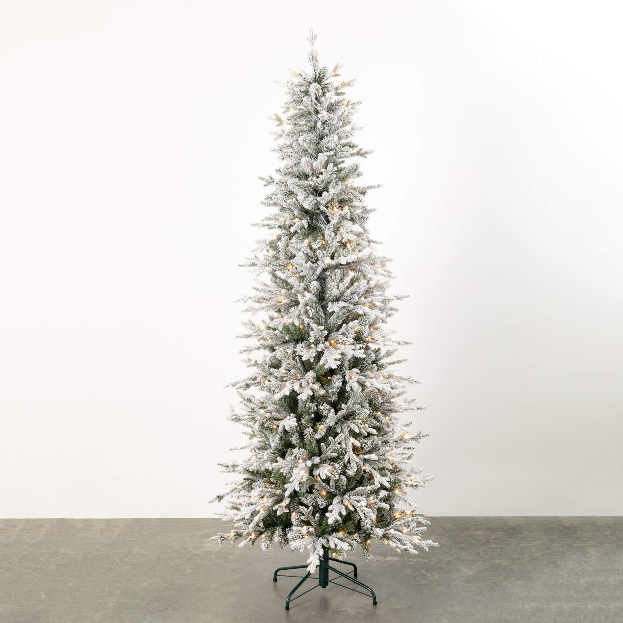 7.5-foot white plastic pencil Christmas tree with flocked snow texture and warm multi-colored LED lights.