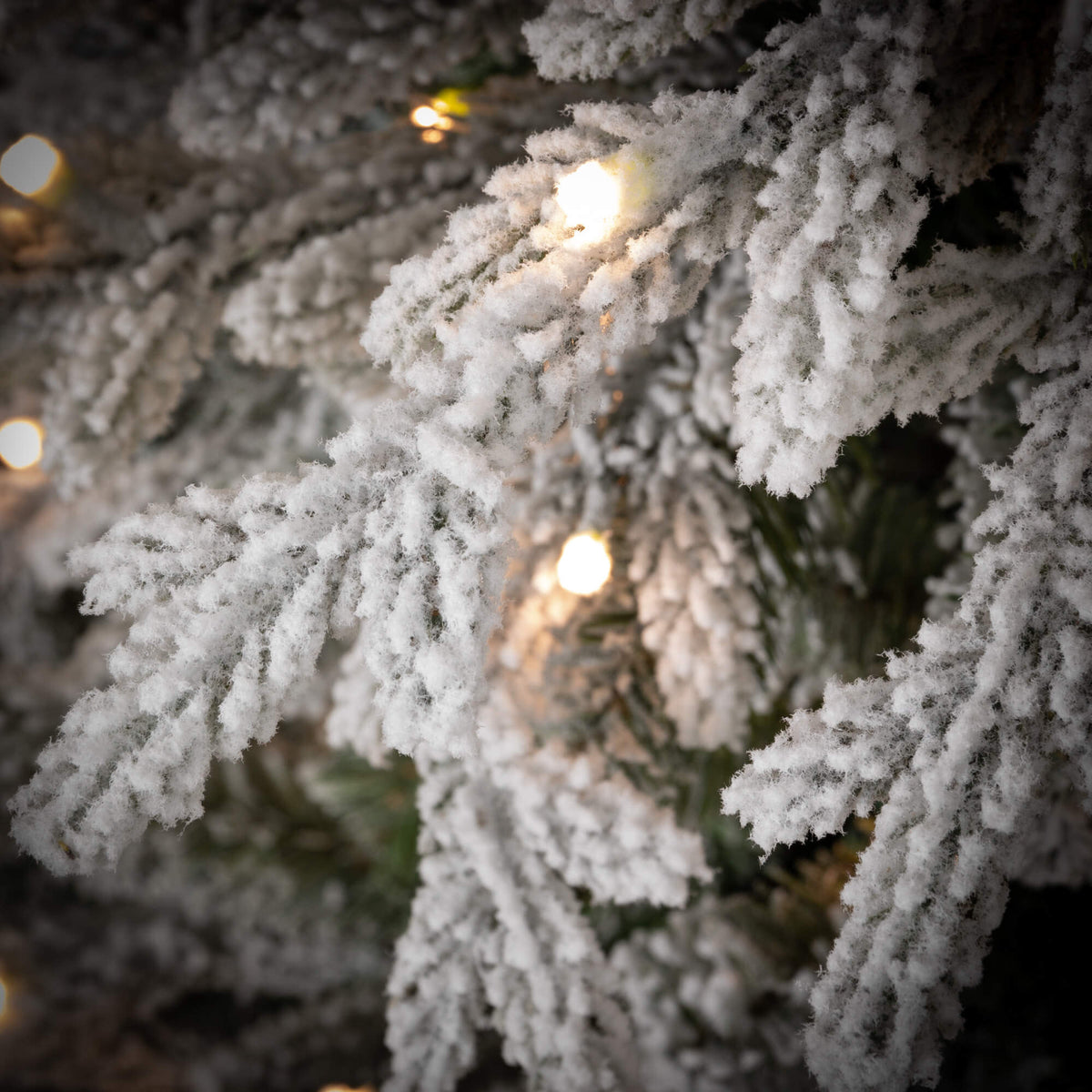 7.5-foot LED pencil Christmas tree with white flocked snow finish and warm multi-colored lights.