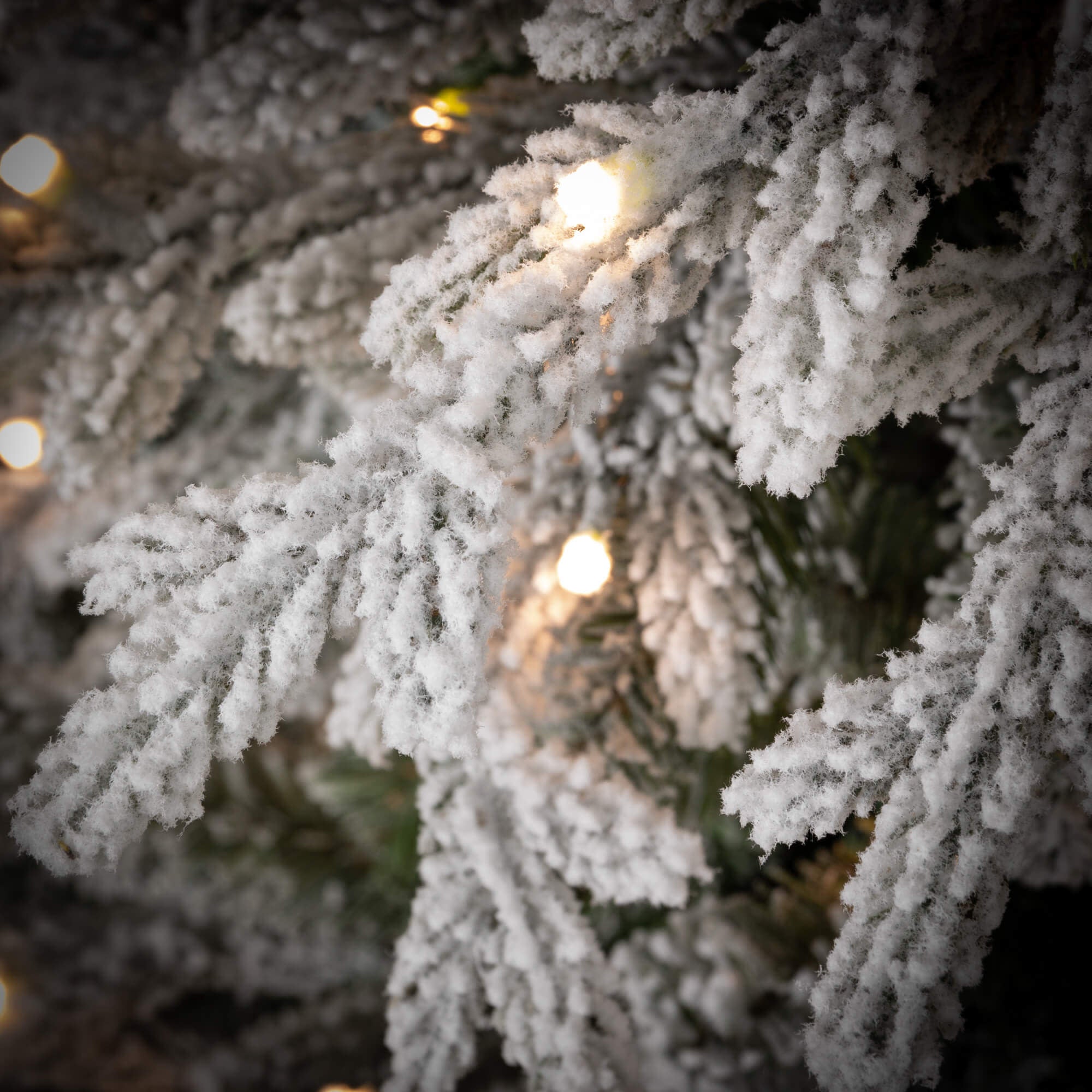 7.5-foot LED pencil Christmas tree with white flocked snow finish and warm multi-colored lights.