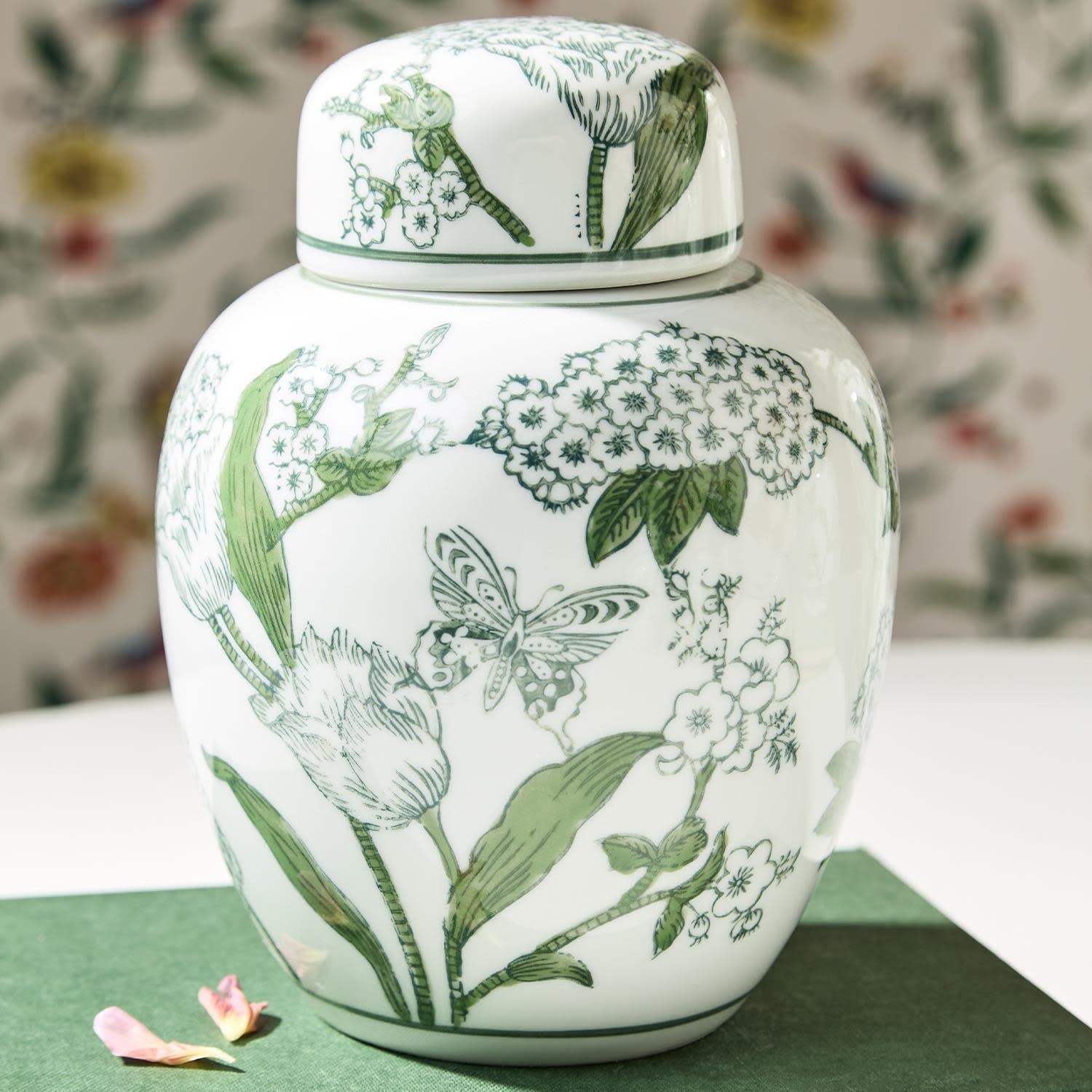 Hand-painted porcelain ginger jar with lid featuring green and white chinoiserie primrose and lotus pattern.
