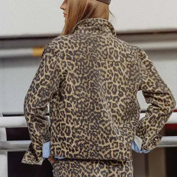 Back view of a woman wearing a leopard print denim jacket with blue cuffs and matching pants.