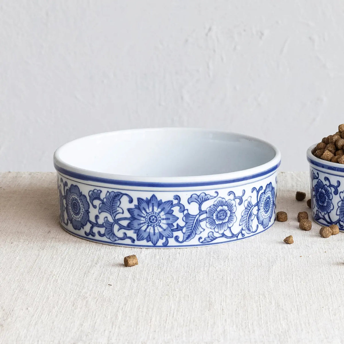 Round stoneware pet bowl with floral pattern in earthy tones