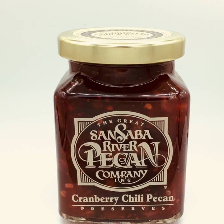 Glass jar containing Texas cranberry preserves with pecans