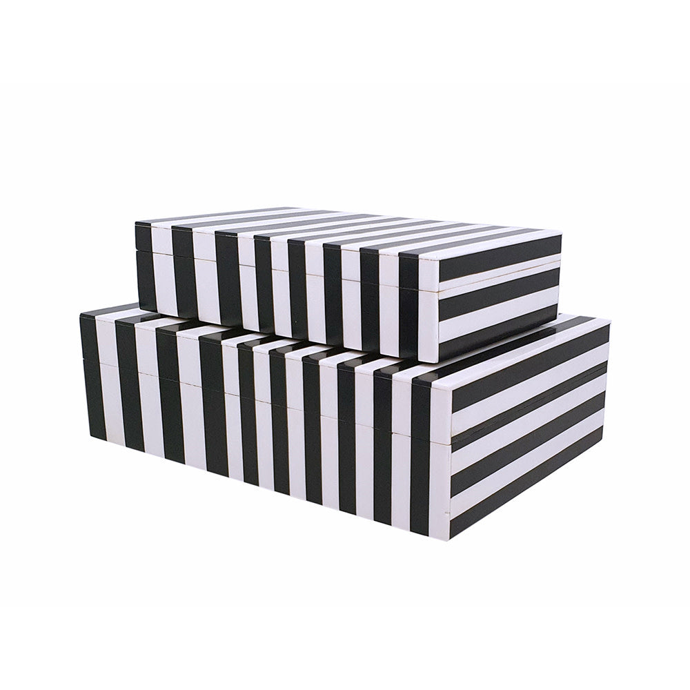 Black and white striped Jacey lidded box with resin accents displayed on a coffee table shelf.
