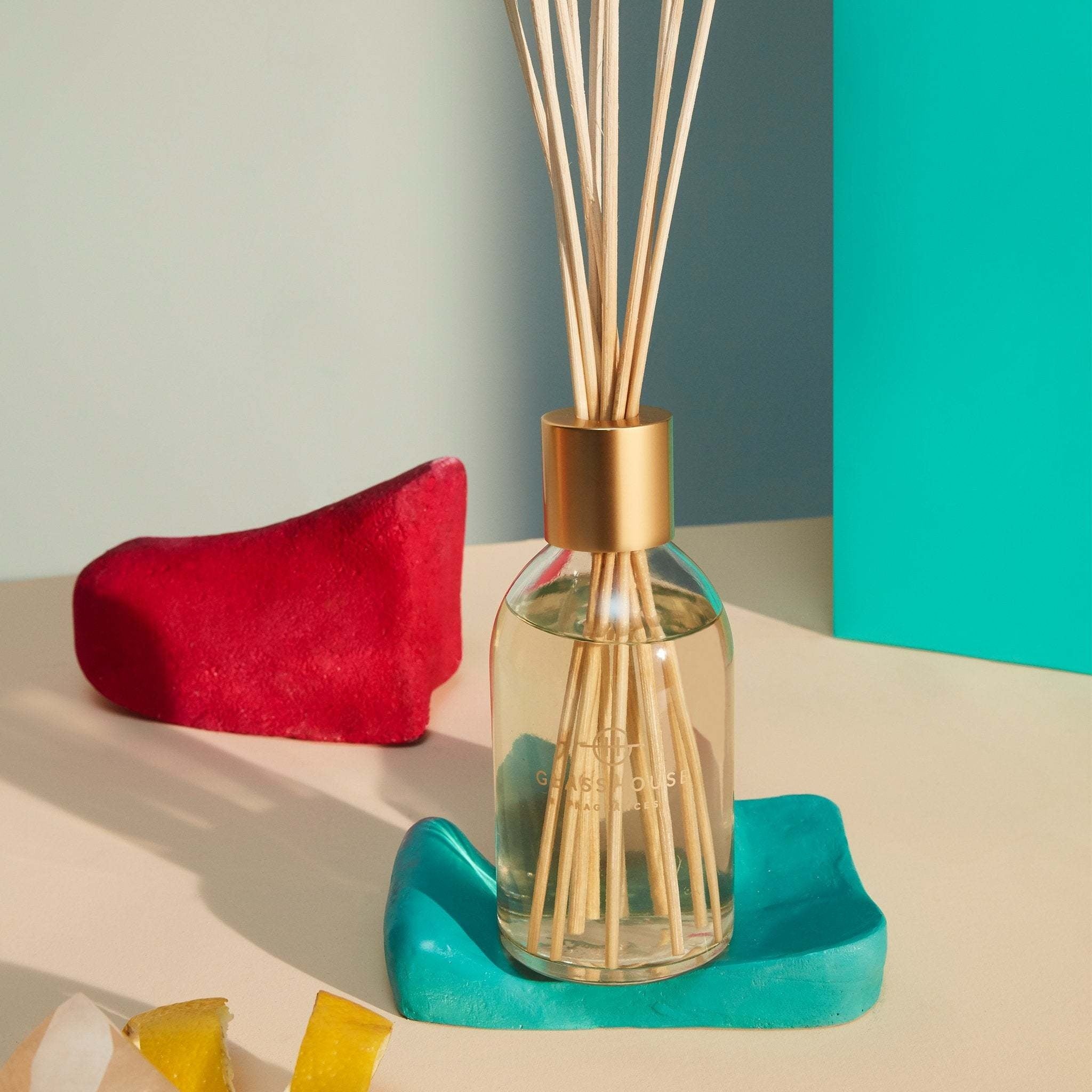 Glasshouse One Night in Rio diffuser with glass bottle containing pink liquid and wooden reeds.
