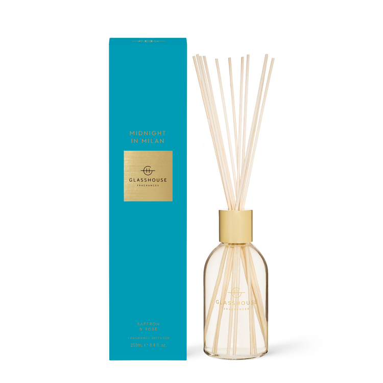Midnight in Milan diffuser bottle with dark glass, rose-colored liquid, and wooden reeds.