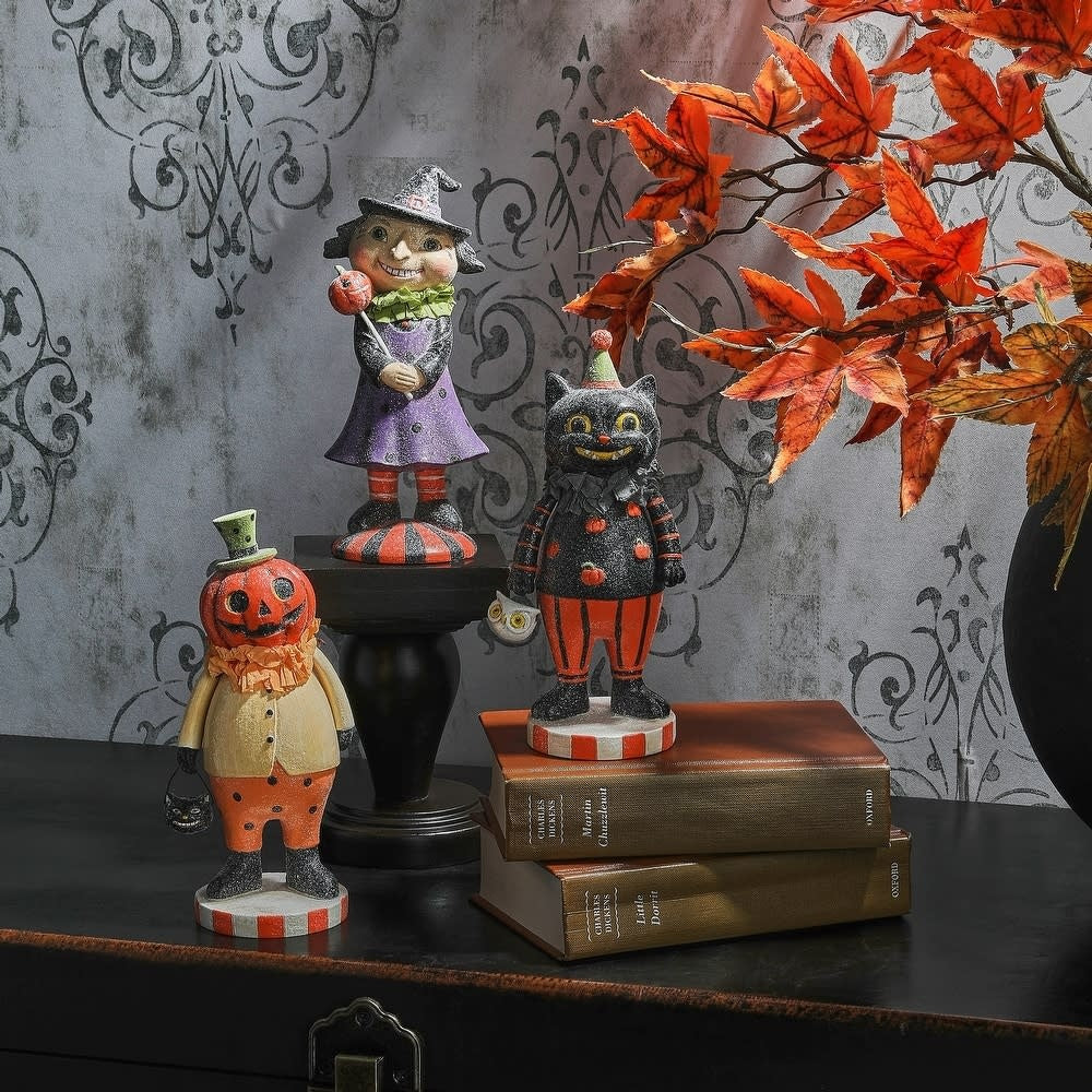 Hand-painted resin retro Halloween child figure with sugared finish in orange and black.