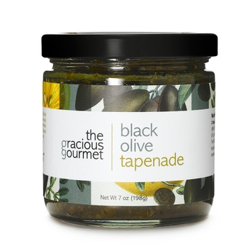 Open jar of black olive tapenade with visible herbs in extra virgin olive oil