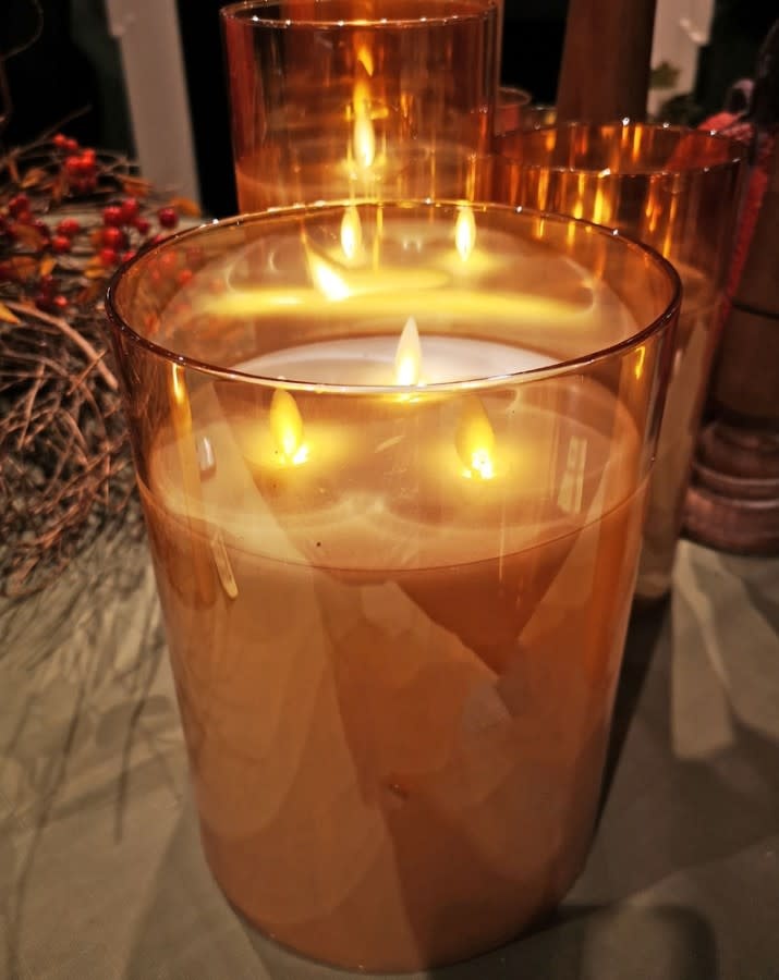 Amber glass candle with three wicks in an 8-inch cylindrical silhouette.