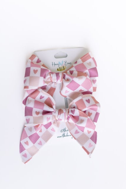 Red satin Valentine bow measuring 3.5 inches wide with a central knot.