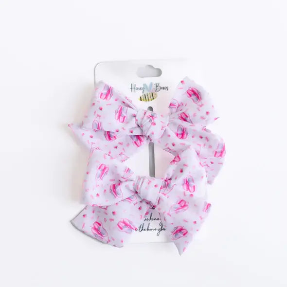Small closed-edge strip ballet bow on clip in light pink fabric
