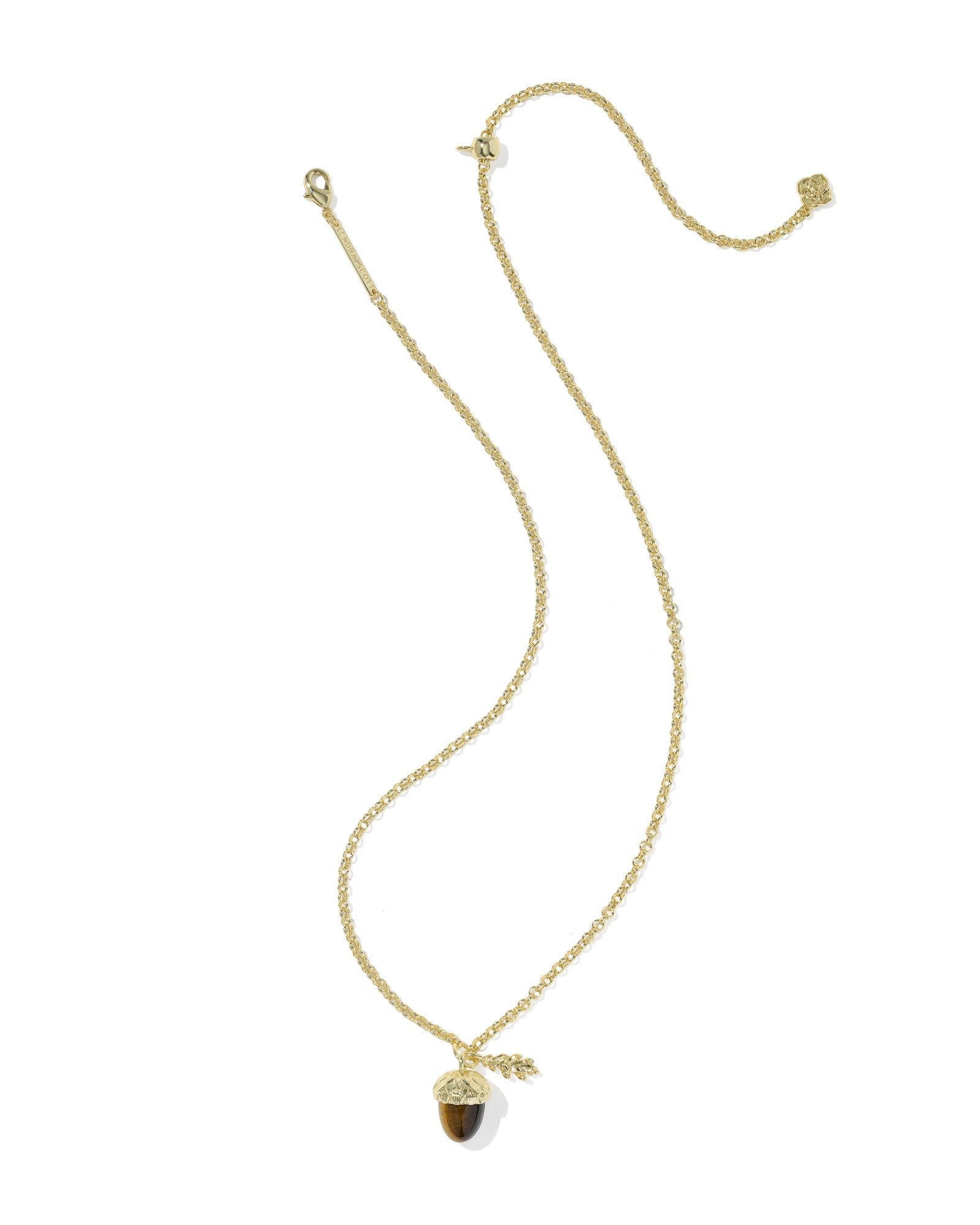 Gold chain necklace with a tiger's eye acorn pendant and a small gold leaf charm.