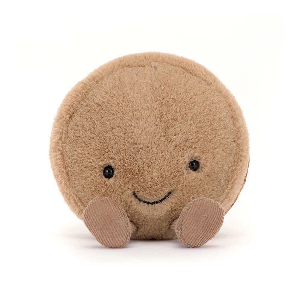 Amuseables Mona Macaron plush toy, a round tan macaron with a smiling face and corduroy feet.