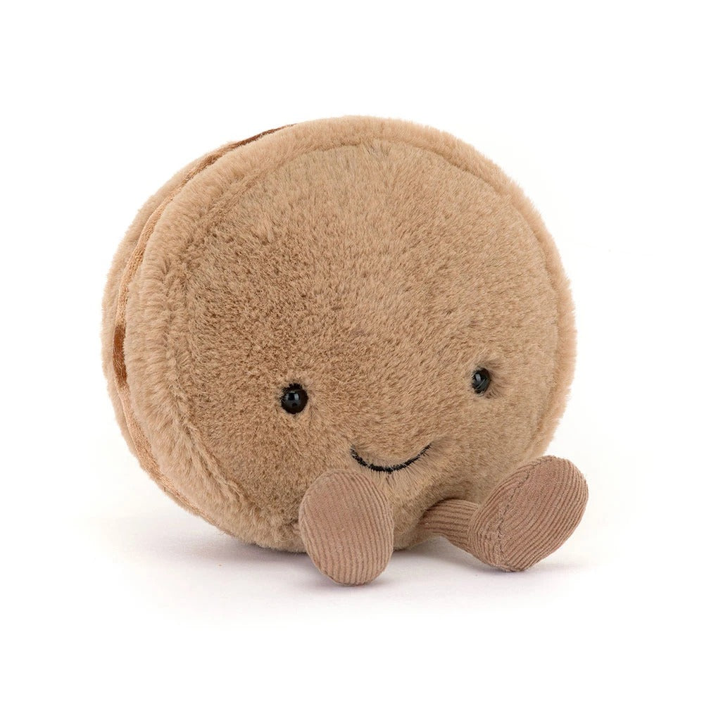 Amuseables Mona Macaron plush toy, a round beige macaron with a smiling face and corduroy legs.