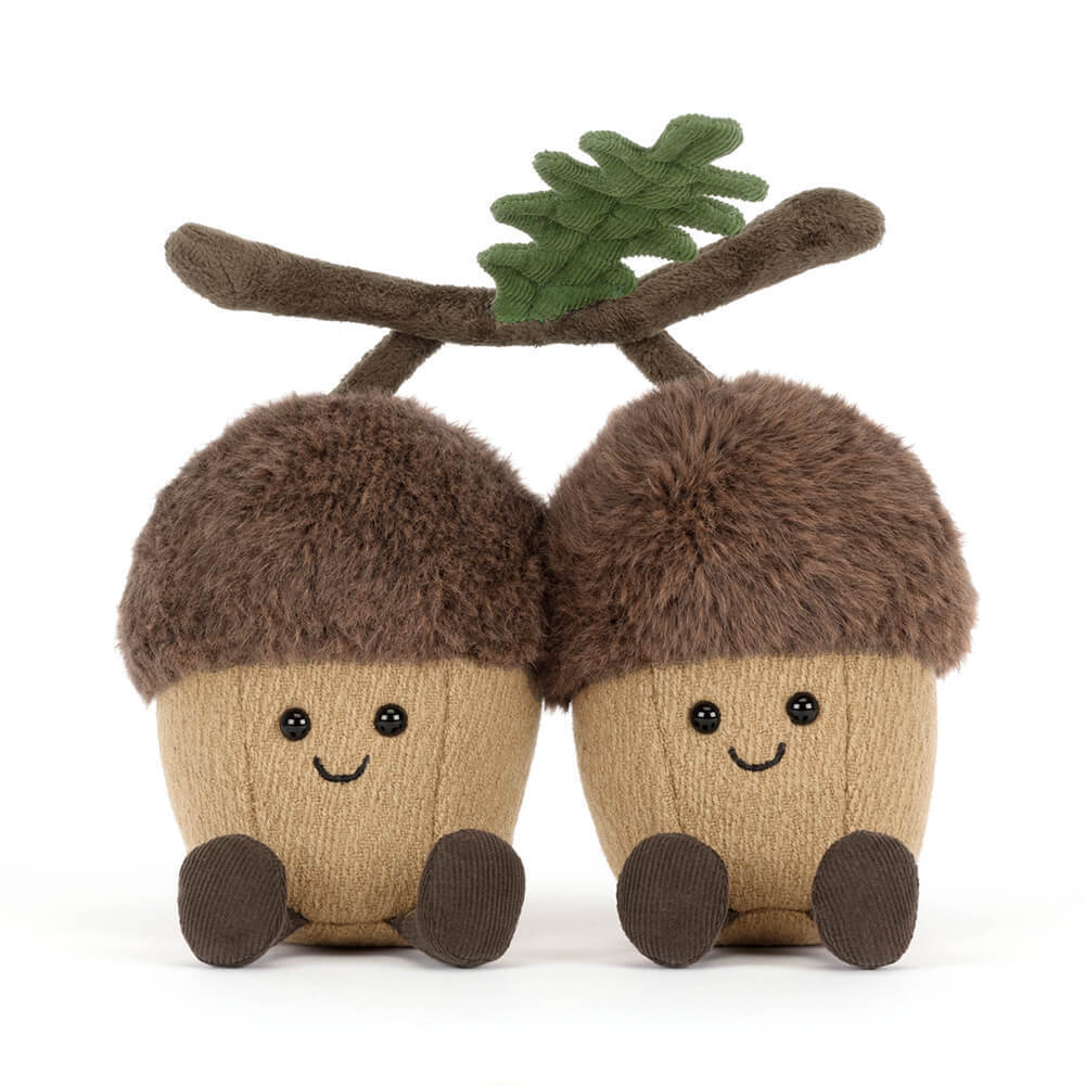 Two plush acorns with fuzzy brown caps, tan bodies, smiling faces, and small corduroy feet.