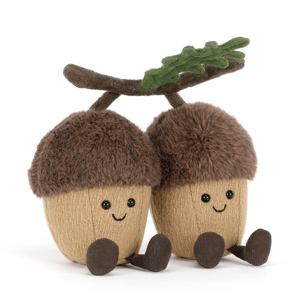 Two plush acorns with smiling faces, brown fuzzy caps, and tan bodies joined by a branch and leaf.