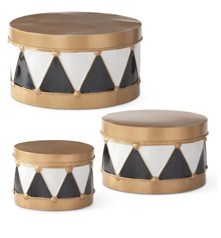 Three gold, black, and white harlequin metal drum containers in varying sizes.