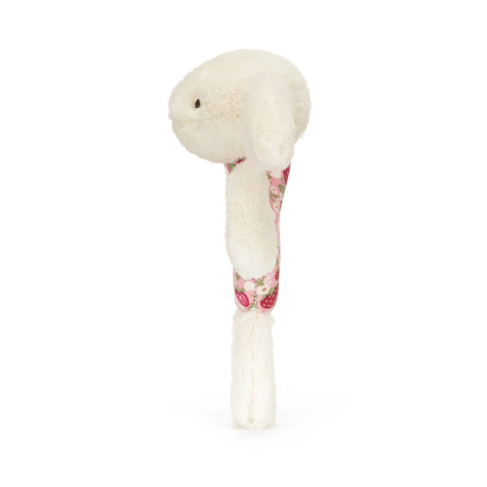 Side view of a Blossom Cream Bunny 'Berry' Ring Rattle with a floral strawberry print handle.
