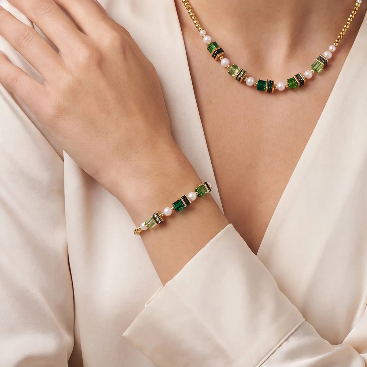 Bracelet Sparkling Princess Gold-Emerald with green crystals and pearls on a woman's wrist.