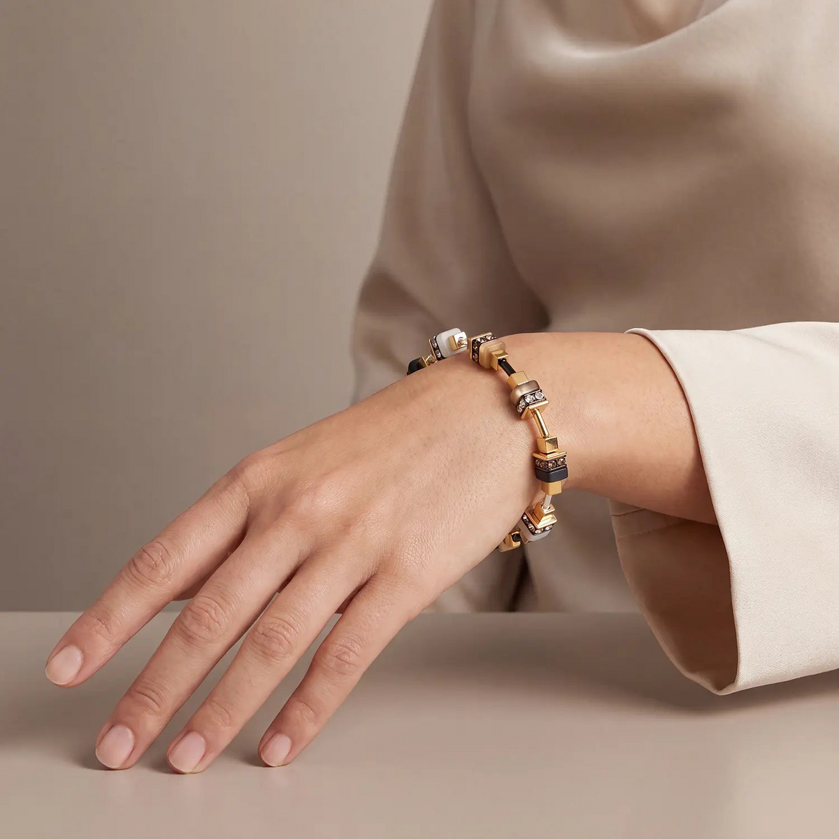 Bracelet Urban Nature Cube Beige-Gold on a woman's wrist, featuring beige, gold, and black cubes.