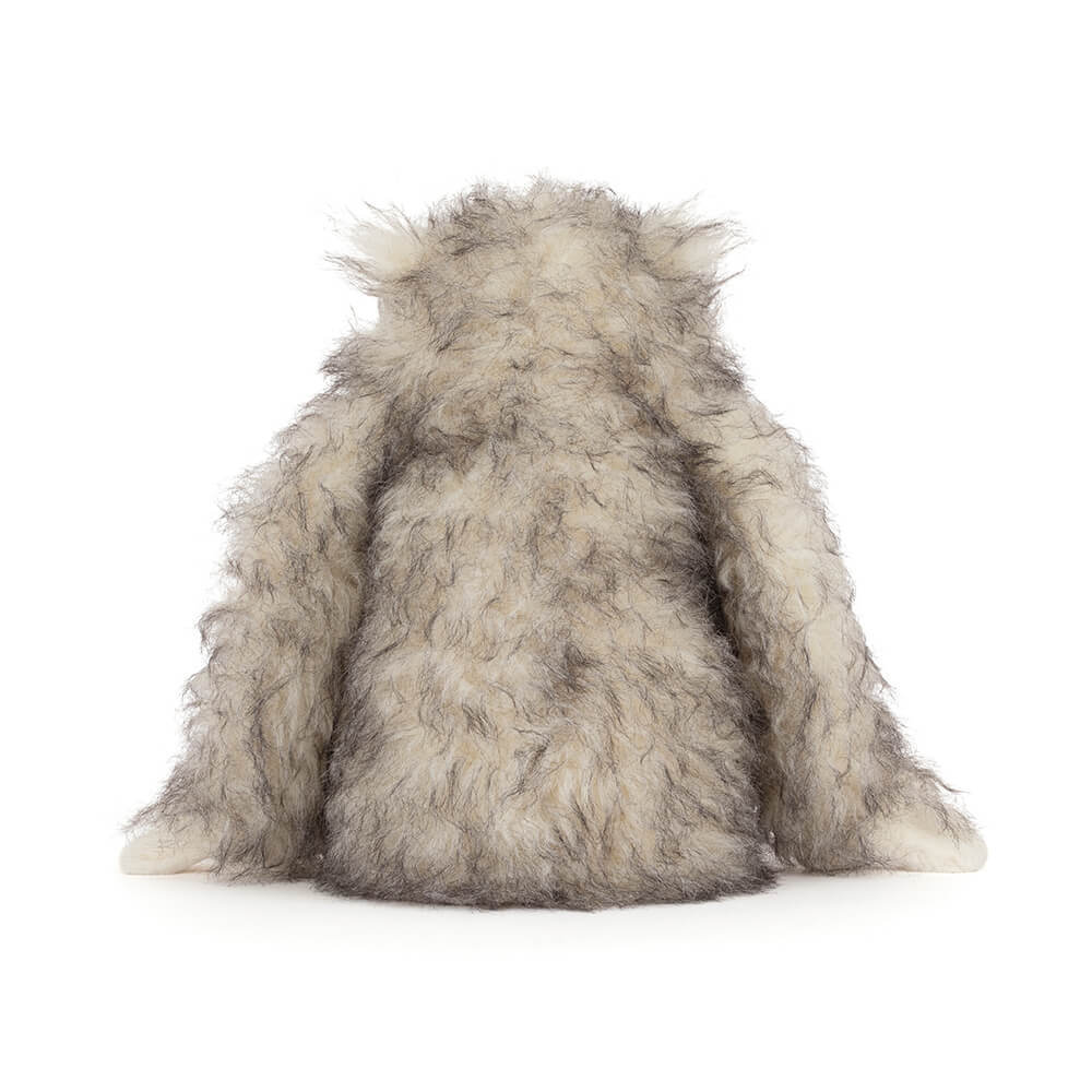 Back view of Bretti Yeti, a plush toy with long, shaggy cream and grey faux fur.